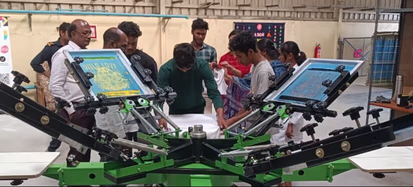 Trainees working on a multi-colour screen printing carousel